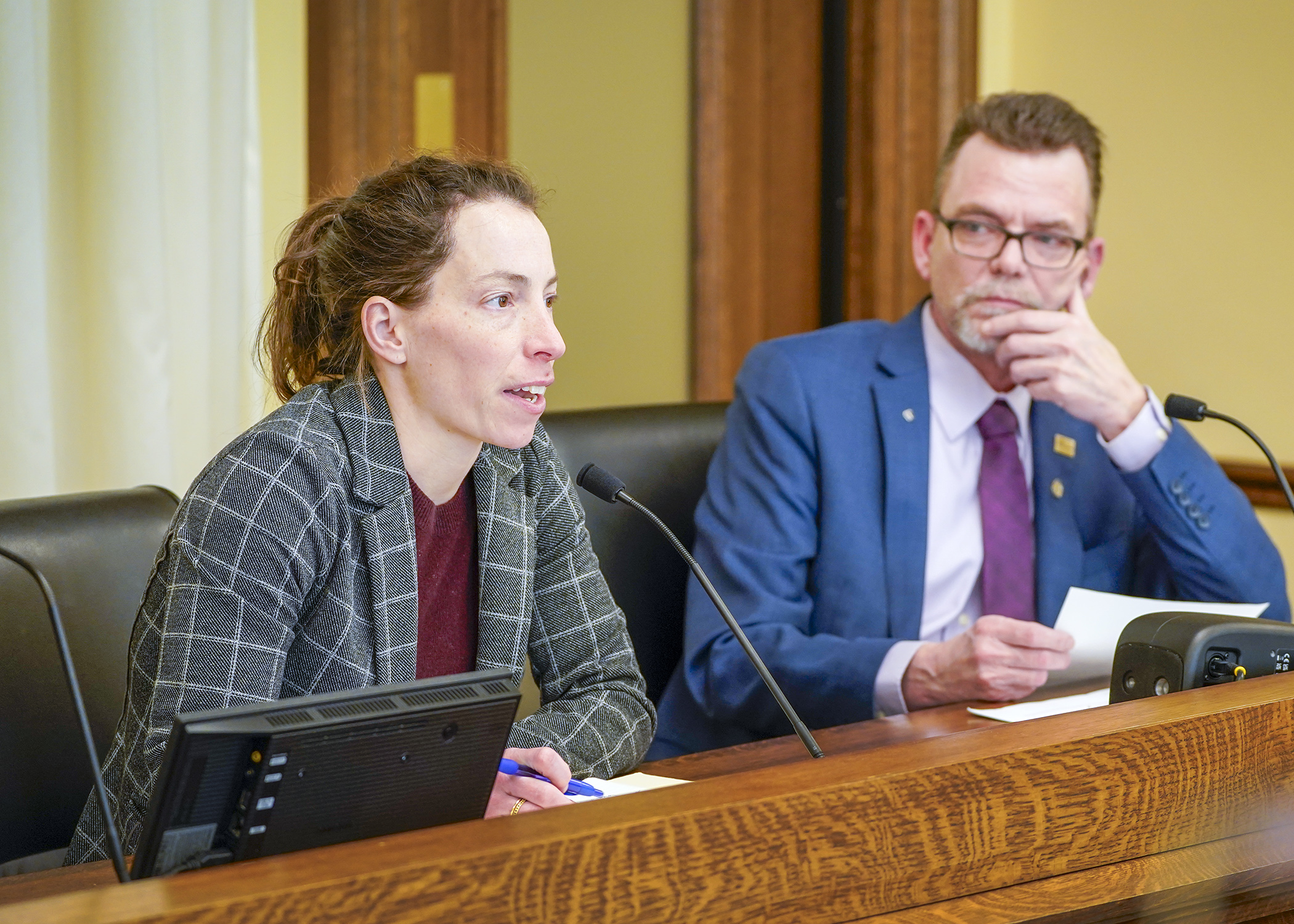 Sydnie Lieb, an assistant commissioner with the Commerce Department, testifies before the House energy committee Feb. 13 on a bill to provide data center energy generation redundancy. Rep. Shane Mekeland, right, sponsors the bill. (Photo by Andrew VonBank)